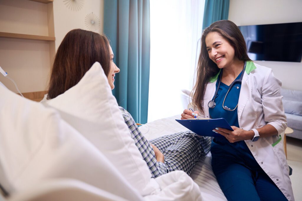 Female Physician Assistant demonstrating excellent bedside manner while talking to a patient.